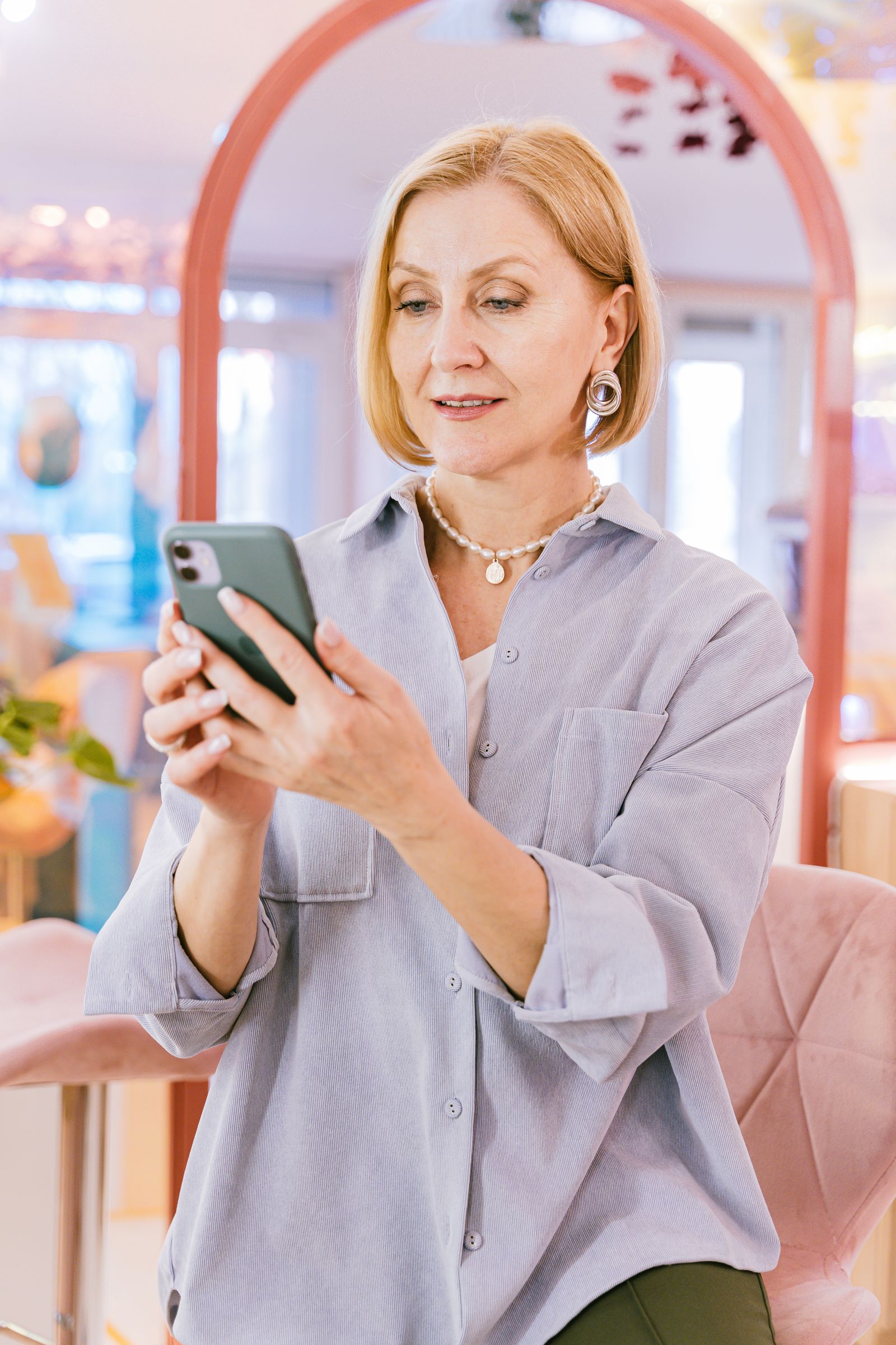 Cliente dans un salon de beauté consultant son smartphone